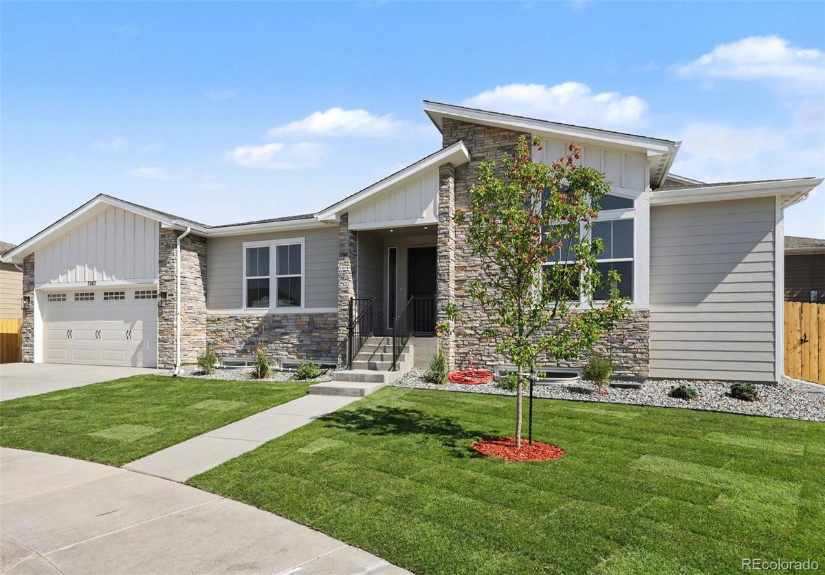Front exterior of a two-story home with siding and brick accents
